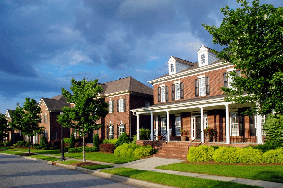 gorgeous brick homes with front porches on a well-maintained neighborhood street